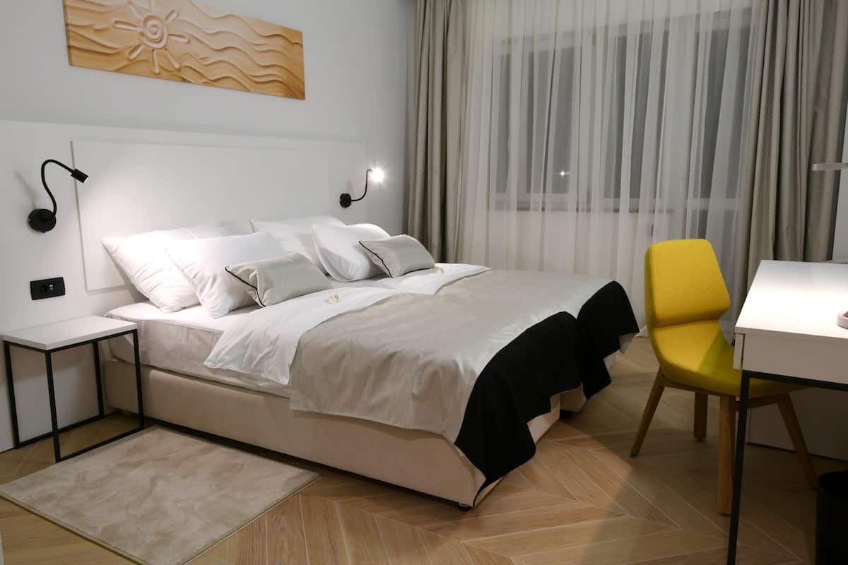 A modern bedroom with a bed, a desk, and a chair.