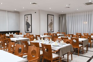 A dining area with multiple tables and chairs, each set with plates, glasses, and cutlery. - Aparthotel Milenij (Baska Voda)