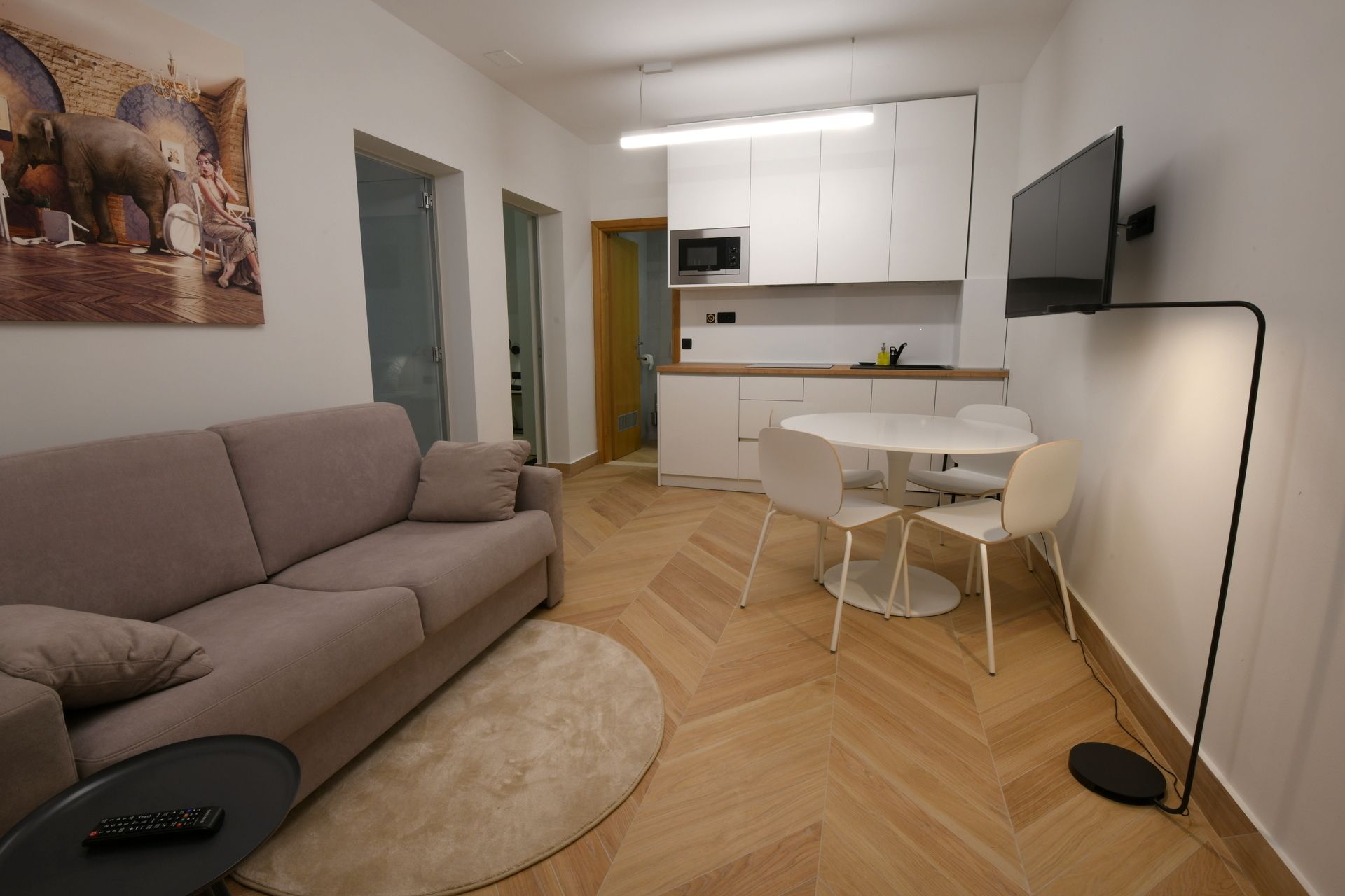 Ein modernes Wohnzimmer mit einer Couch, einem runden Couchtisch und einem Fernseher.