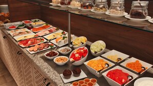 A buffet with various food items including meats, fruits, and pastries. - H+ Hotel Lübeck (Lübeck)