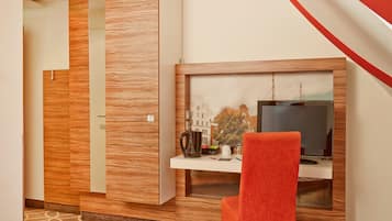Una habitación moderna con una pared de acento de madera, un escritorio con televisor y una silla roja.