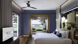 Un moderno cuarto de hotel con una cama grande, televisión y vista al océano.