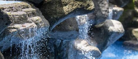 A rock formation with a water stream flowing over it.