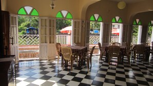 A restaurant with checkered flooring, wooden tables, and chairs. - Hotel Riverside (Baga)