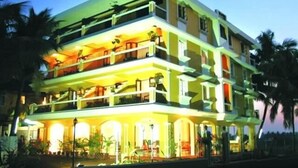A multi-story hotel with balconies and a well-lit entrance. - Ala Goa Resort (Betalbatim)