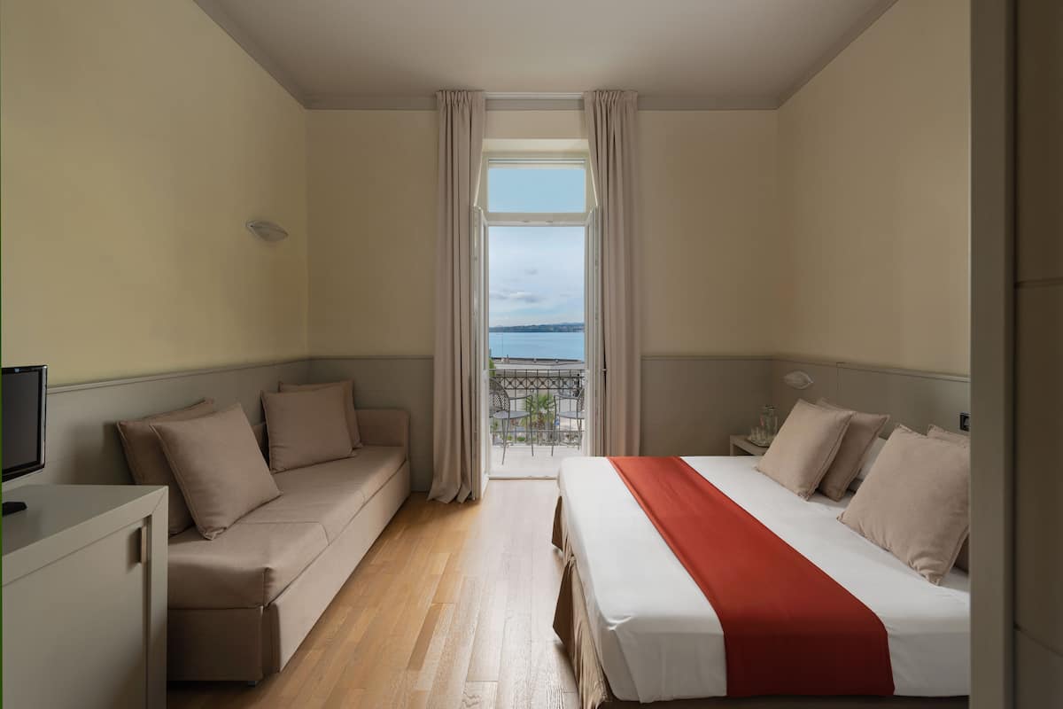 triple room, balcony, lake view | minibar, in-room safe, desk, iron/ironing board