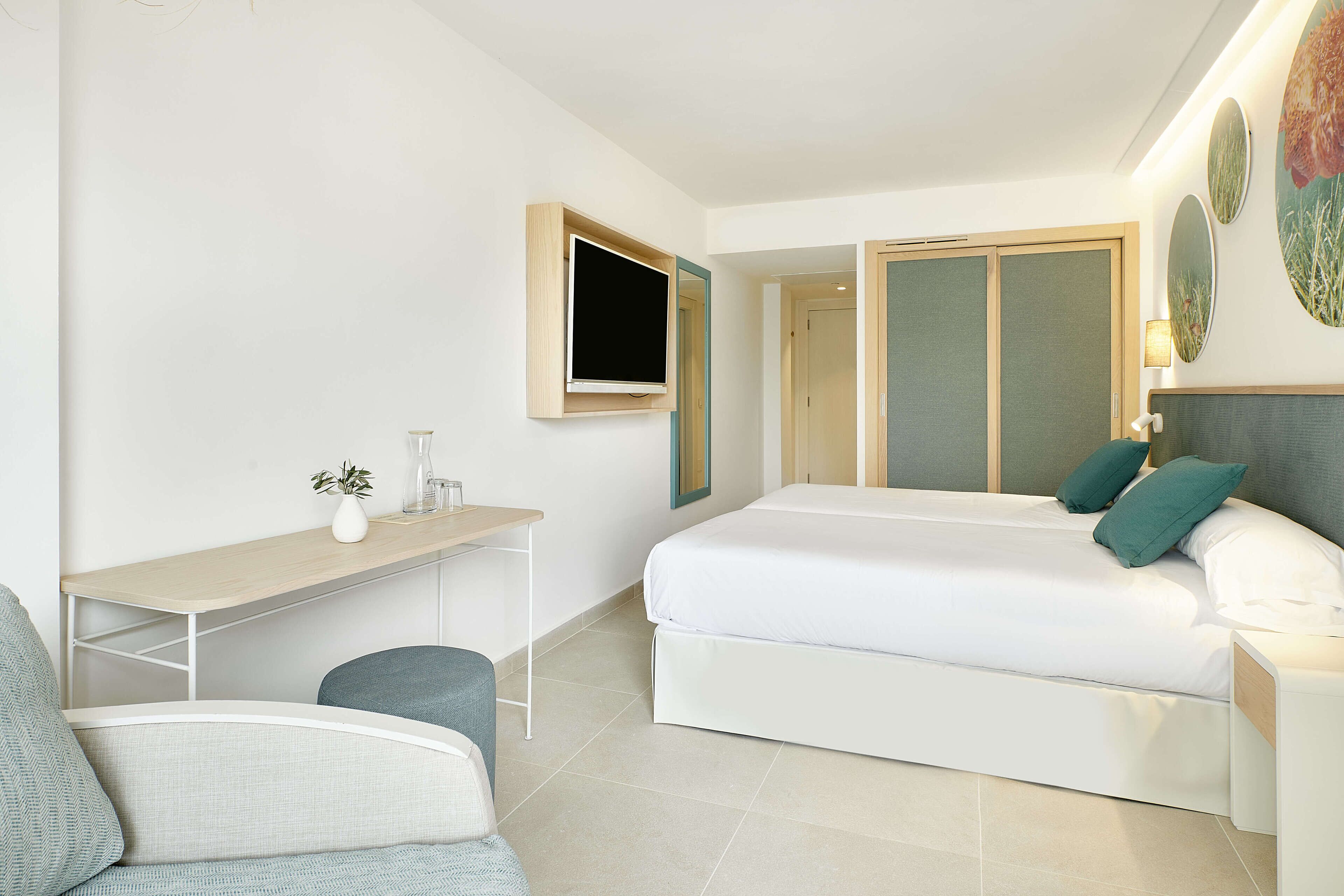 Une chambre d’hôtel moderne équipée d’un lit, d’un bureau, d’une chaise et d’un téléviseur.