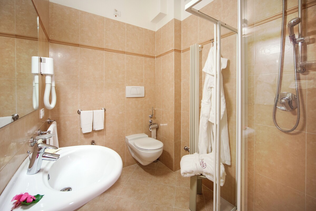 Un baño con lavamanos, inodoro y ducha.