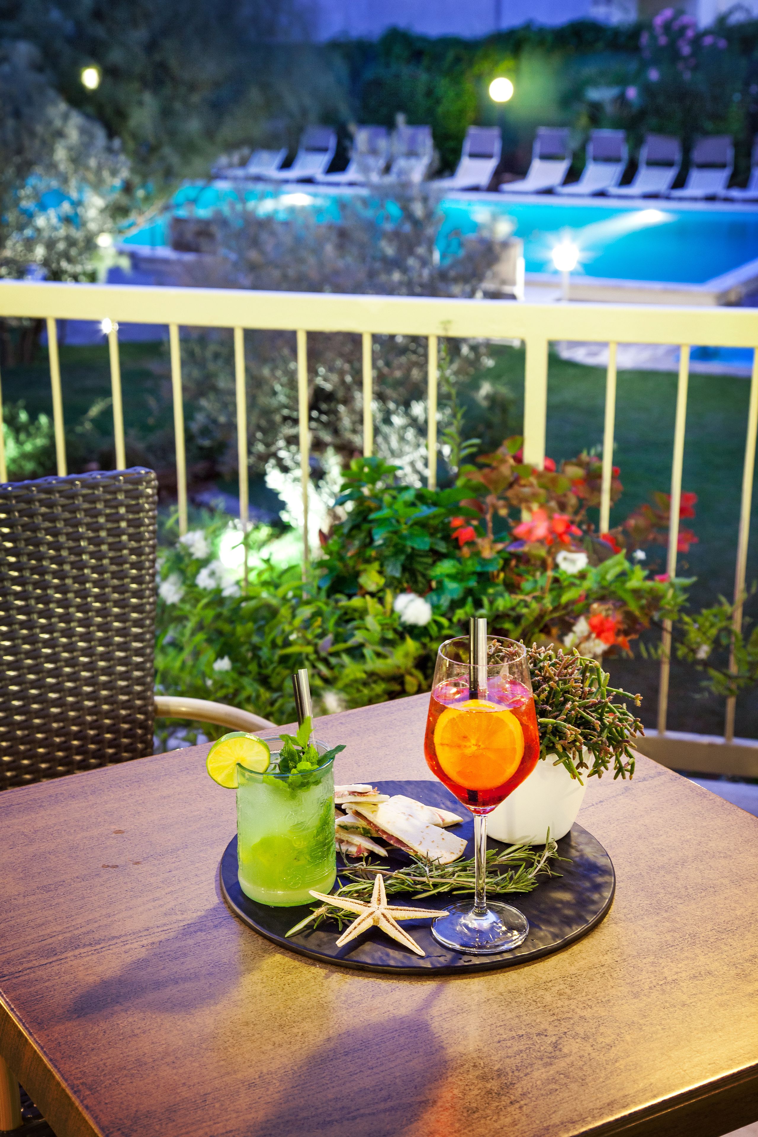 Una mesa con dos bebidas, una verde y otra roja, adornadas y con una decoración de estrella de mar.