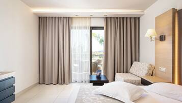 Habitación de hotel con cama, escritorio, silla y vistas al exterior.
