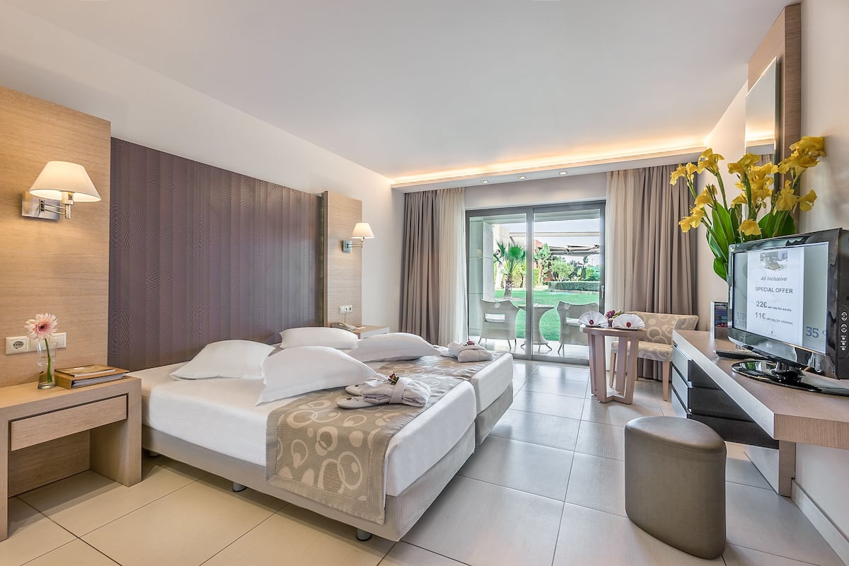 A modern hotel room with a bed, desk, and TV.