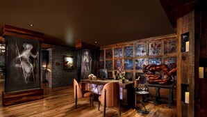 Ein modernes Interieur mit Holzboden, einer Bar und Kunstwerken an den Wänden.
