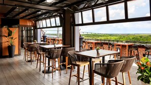 Ein Restaurant mit Außenbereich, großen Fenstern und Blick auf die Landschaft.
