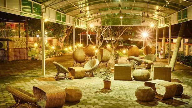 An outdoor seating area with wicker furniture and a hexagonal tiled floor. - VGP Golden Beach Resort (Chennai)