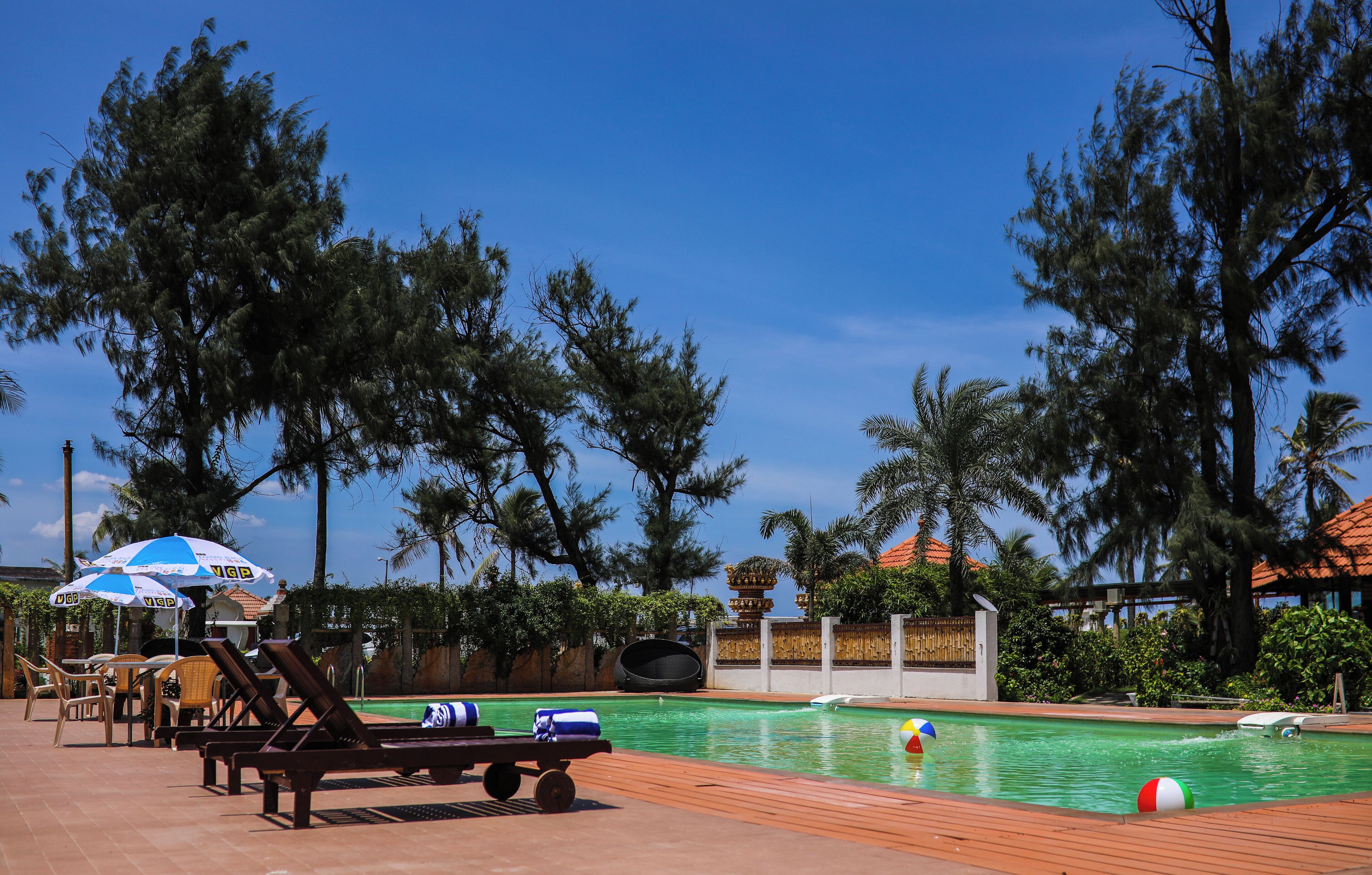 Una piscina al aire libre, sillones reclinables de piscina