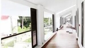 A corridor with wooden flooring and large windows on one side. - VGP Golden Beach Resort (Chennai)