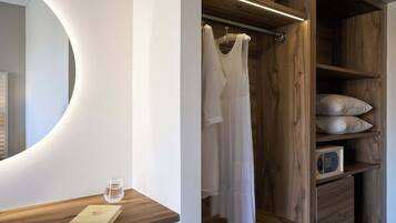 Ein modernes Badezimmer mit einem Holzbadezimmer-Möbelstück, einem runden Spiegel und einer integrierten Duschkabine mit Holztür.