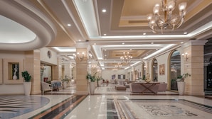 A spacious lobby with a polished marble floor, elegant chandeliers, and comfortable seating areas. - Lindos Imperial Resort & Spa (Rhodes)