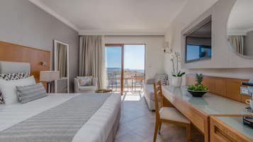 Ein Hotelzimmer mit Bett, Schreibtisch, Stuhl, Fernseher und einem Balkon mit Blick.
