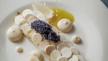 Un dessert servi dans une assiette blanche, nappé d’une sauce.