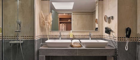 A bathroom with two sinks, a shower, and a mirror.