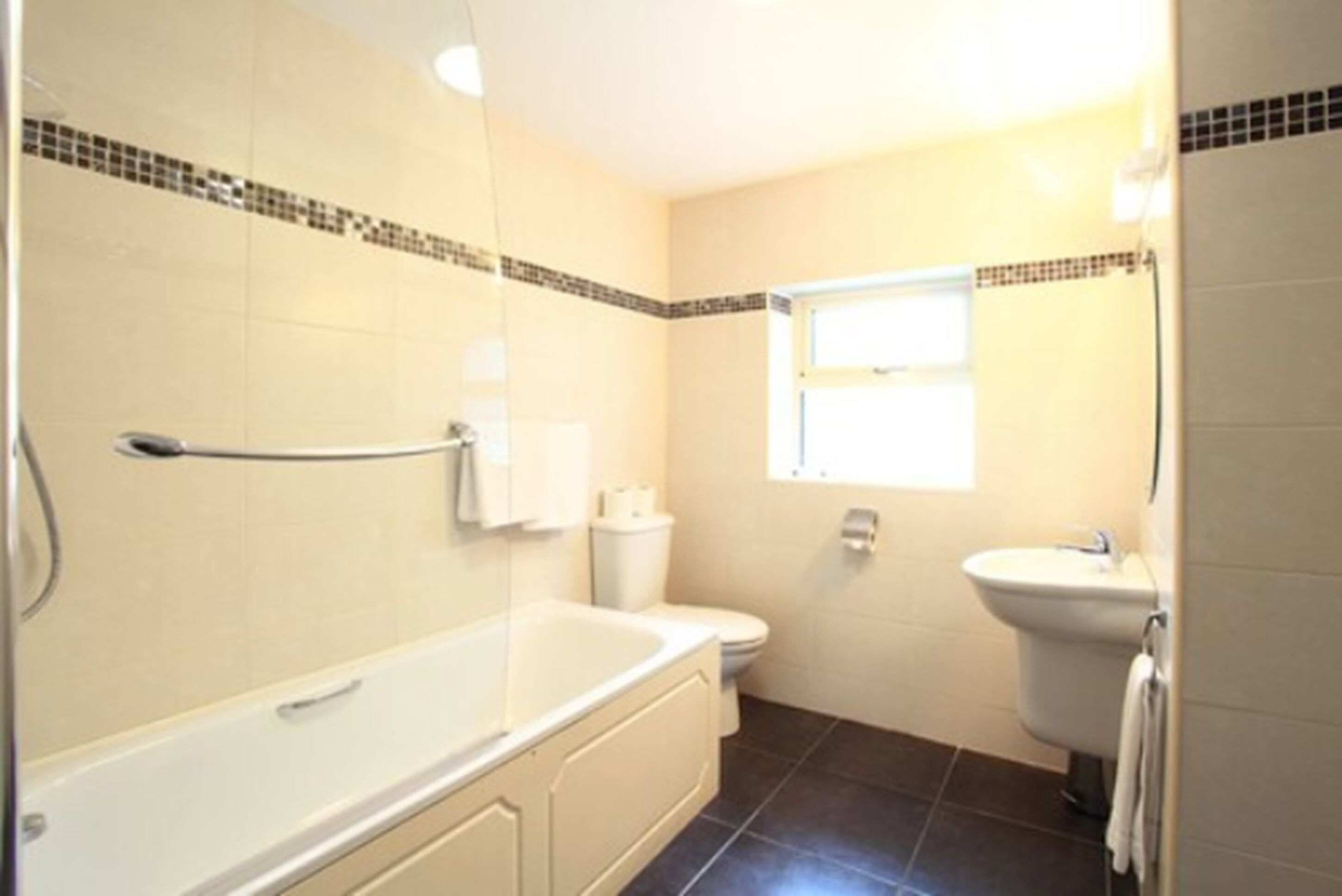 Un bagno con vasca, servizi igienici e lavandino.