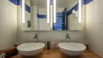 A bathroom with two sinks, a mirror, and a towel rack.