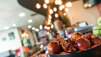 A bowl of pomegranates with a blurred background of a restaurant interior.