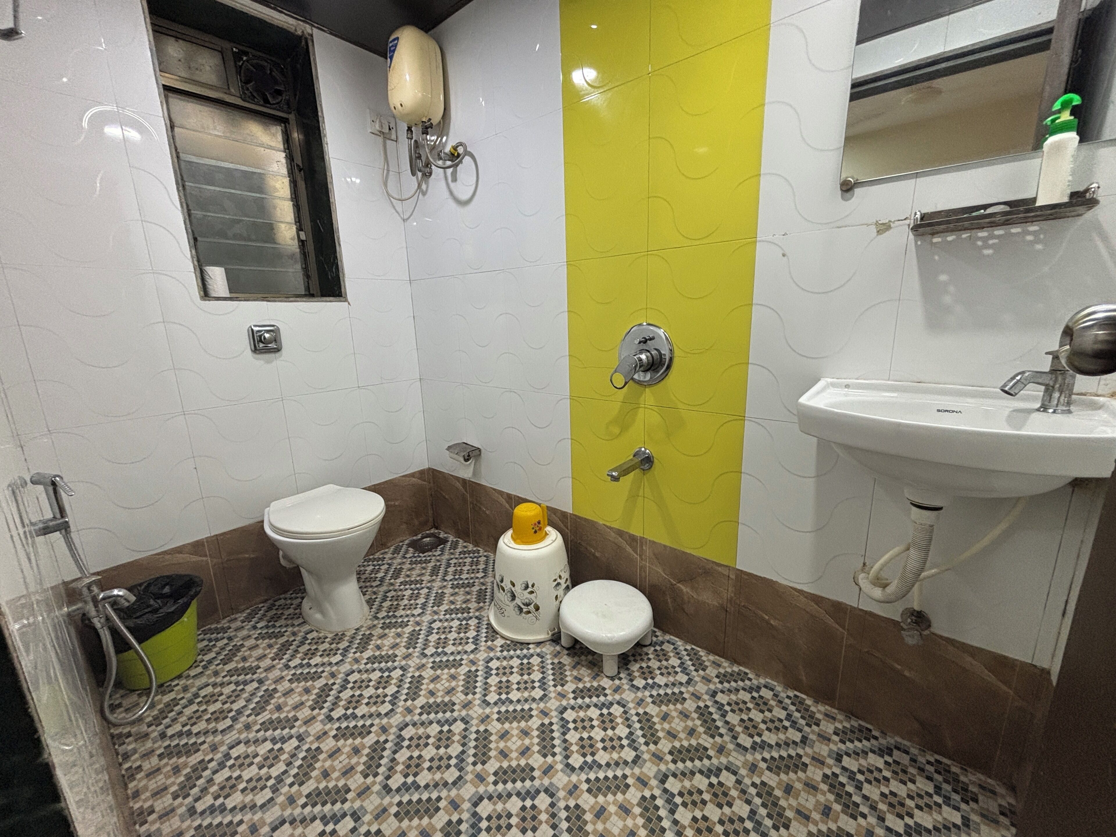 A bathroom with a toilet, bidet, sink, and a mirror.