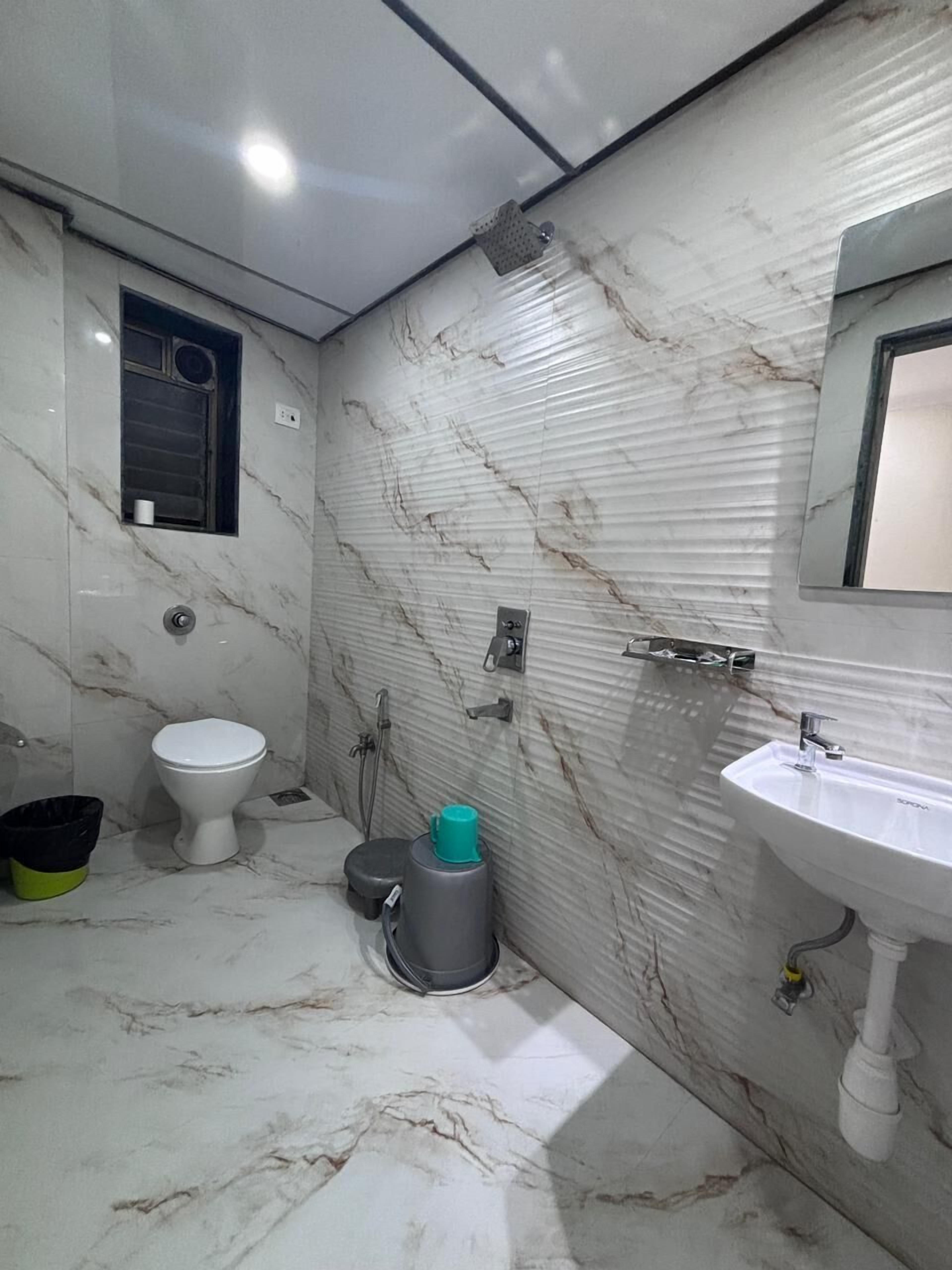 Un baño con inodoro, lavamanos y ducha.