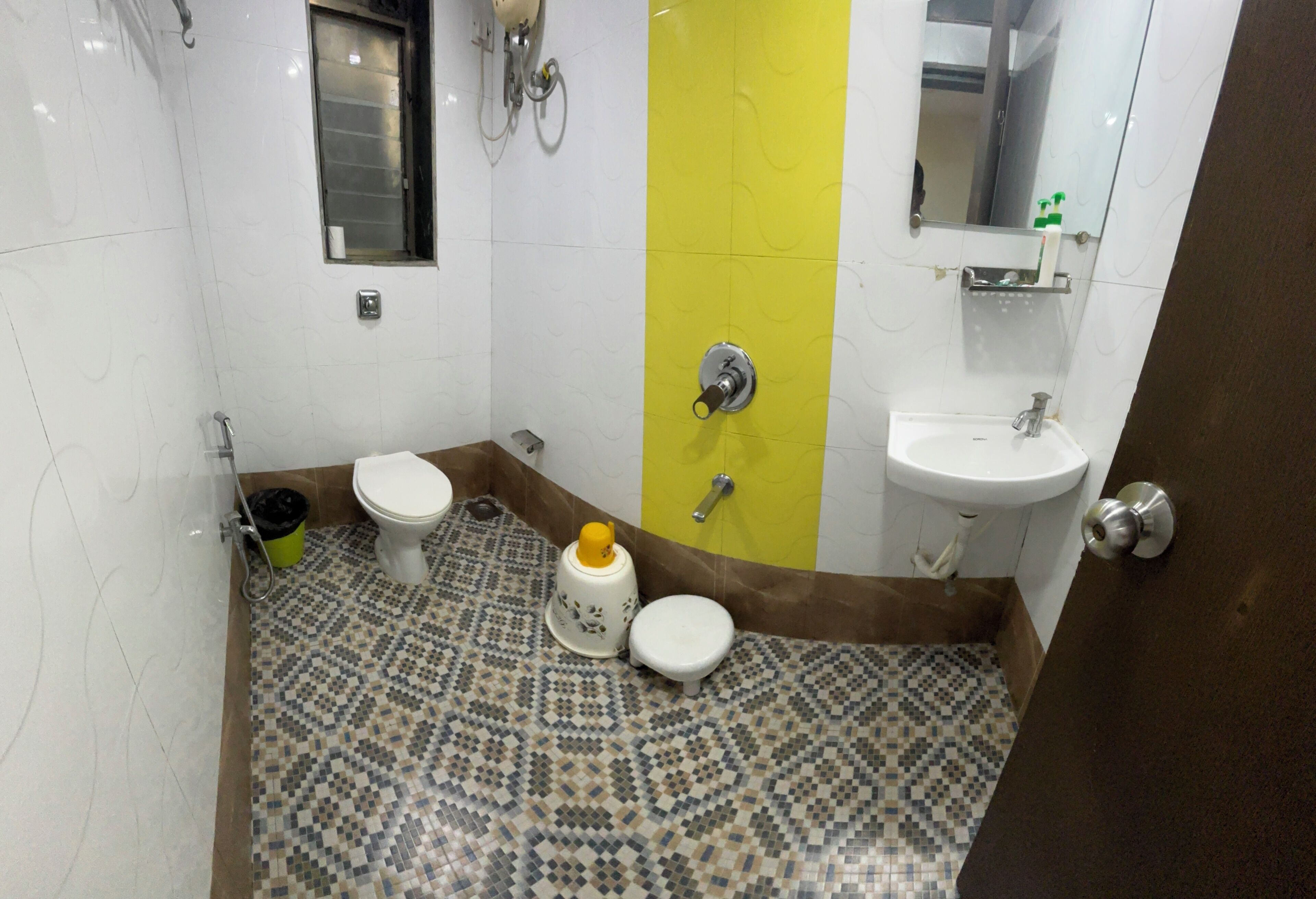 Une salle de bain équipée de toilettes, d’un bidet, d’un lavabo et d’un miroir.