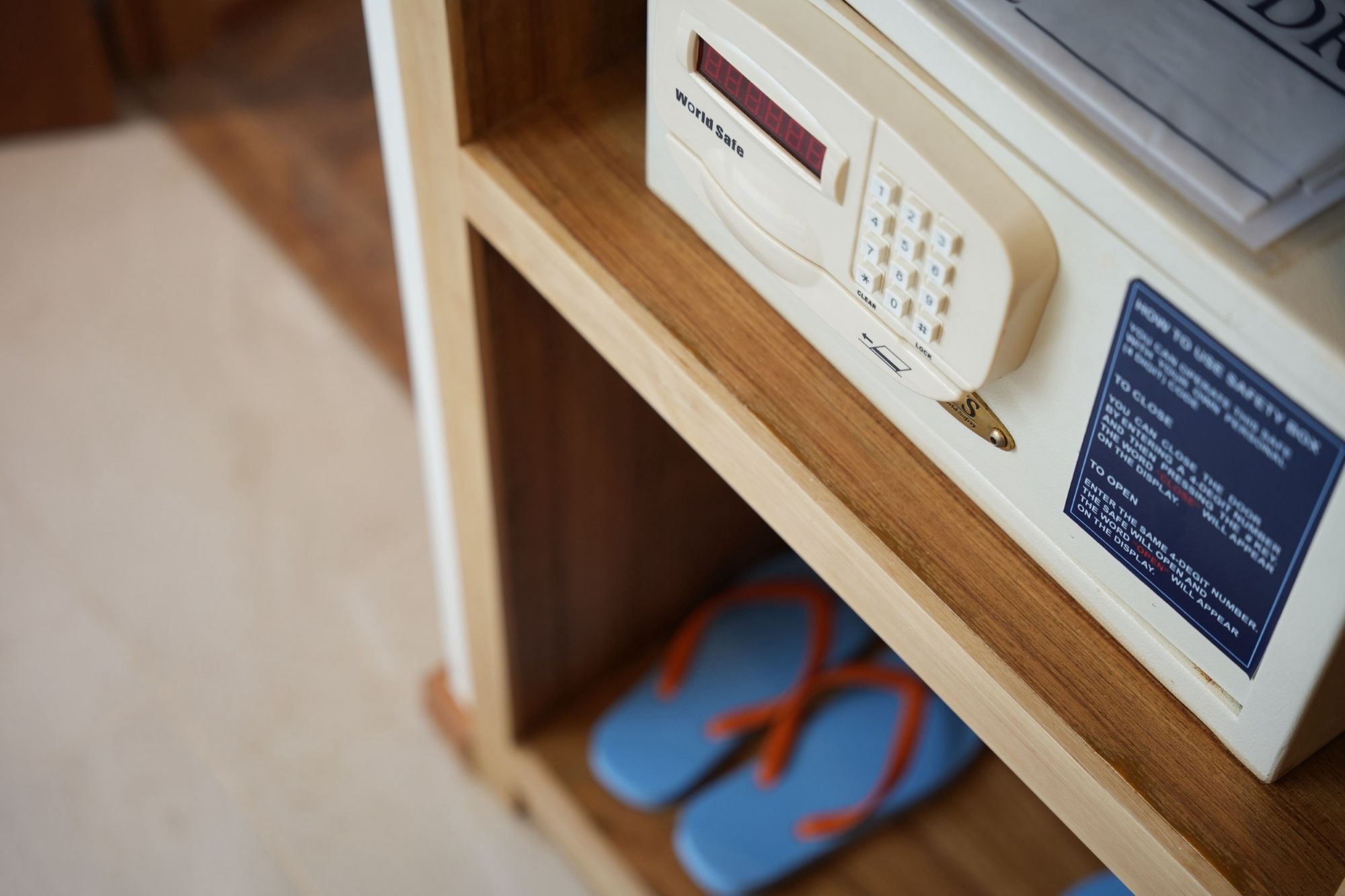 A wooden shelf with a microwave, a digital display, and a safety instruction sign.
