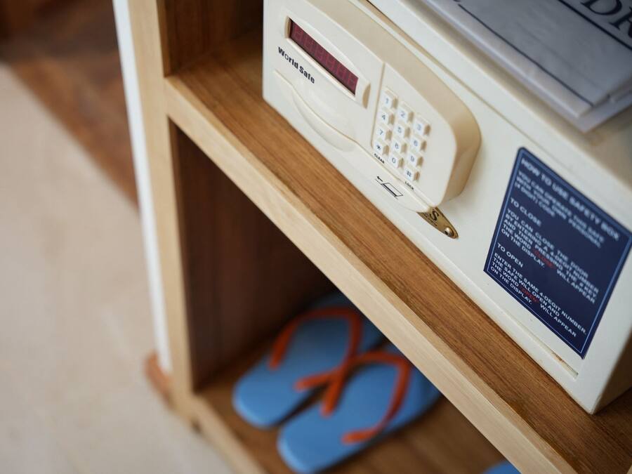 A wooden shelf with a microwave, a digital display, and a safety instruction sign.