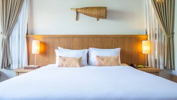 Una habitación de hotel con una cama grande, dos lámparas de noche, un cabecero de madera y un adorno en la pared.