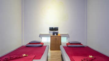 Une chambre avec deux lits, une armoire en bois et un élément décoratif mural.