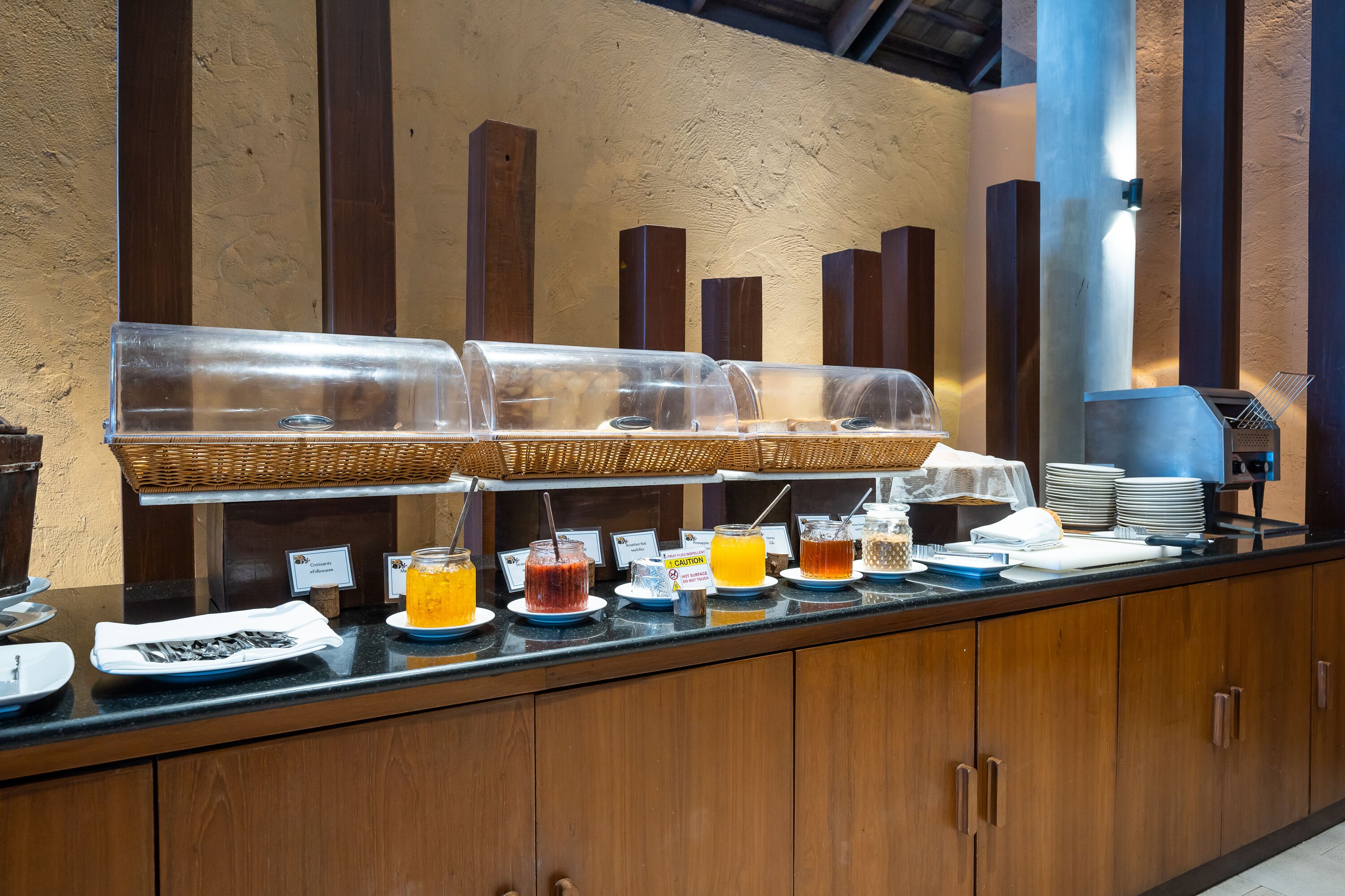 Buffet com diversas opções de comida e bebida, incluindo frutas, sucos e cereais.