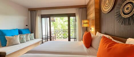 A hotel room with two beds, a sofa, a balcony, and a wooden wall with decorative items.