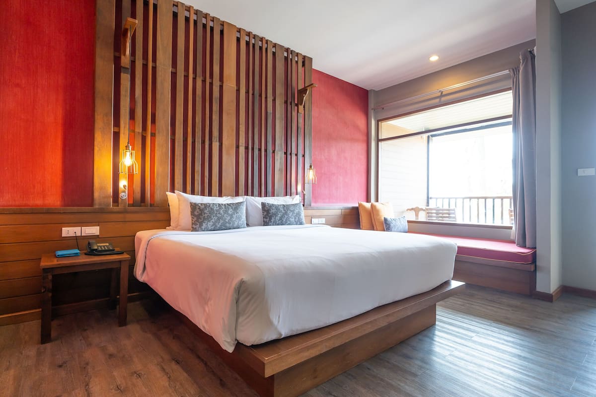 A large bed with a wooden headboard, a bedside table, and a nightstand.