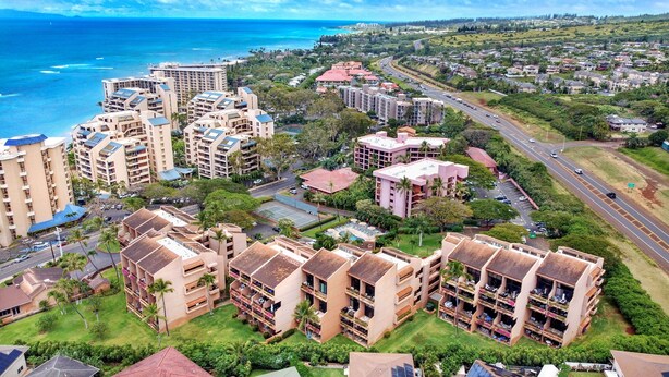 Una zona residenziale lungo la costa con edifici a più piani, una strada e vista sull'oceano.