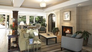 Amplia sala de estar con chimenea, asientos cómodos y vistas al exterior.