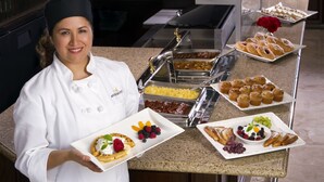 Montaje de bufé con diversas opciones de comida, incluyendo gofres, pastelería y frutas.