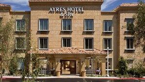 Un hotel con tejado de tejas y un cartel que dice "AYRES HOTEL & SPA".