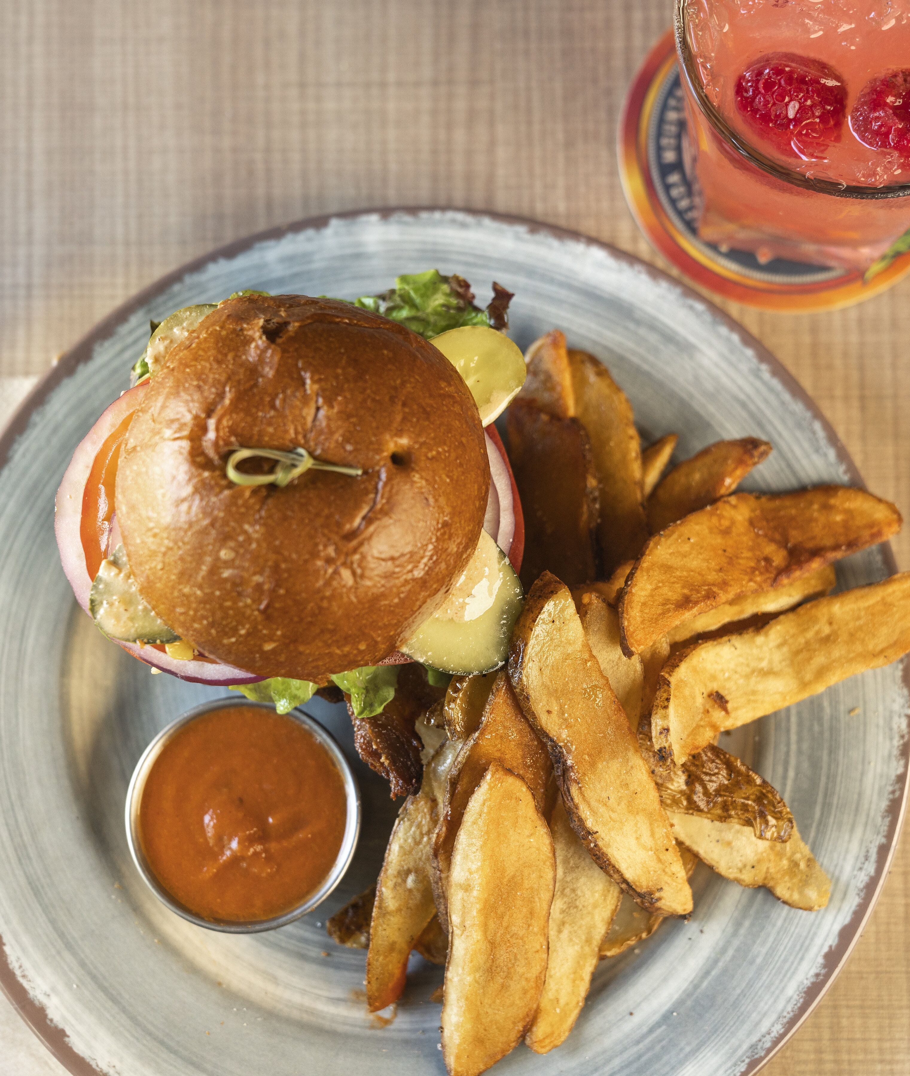 A plate with a burger, fries, and a drink.