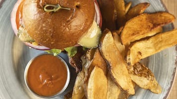A plate with a burger, fries, and a drink.