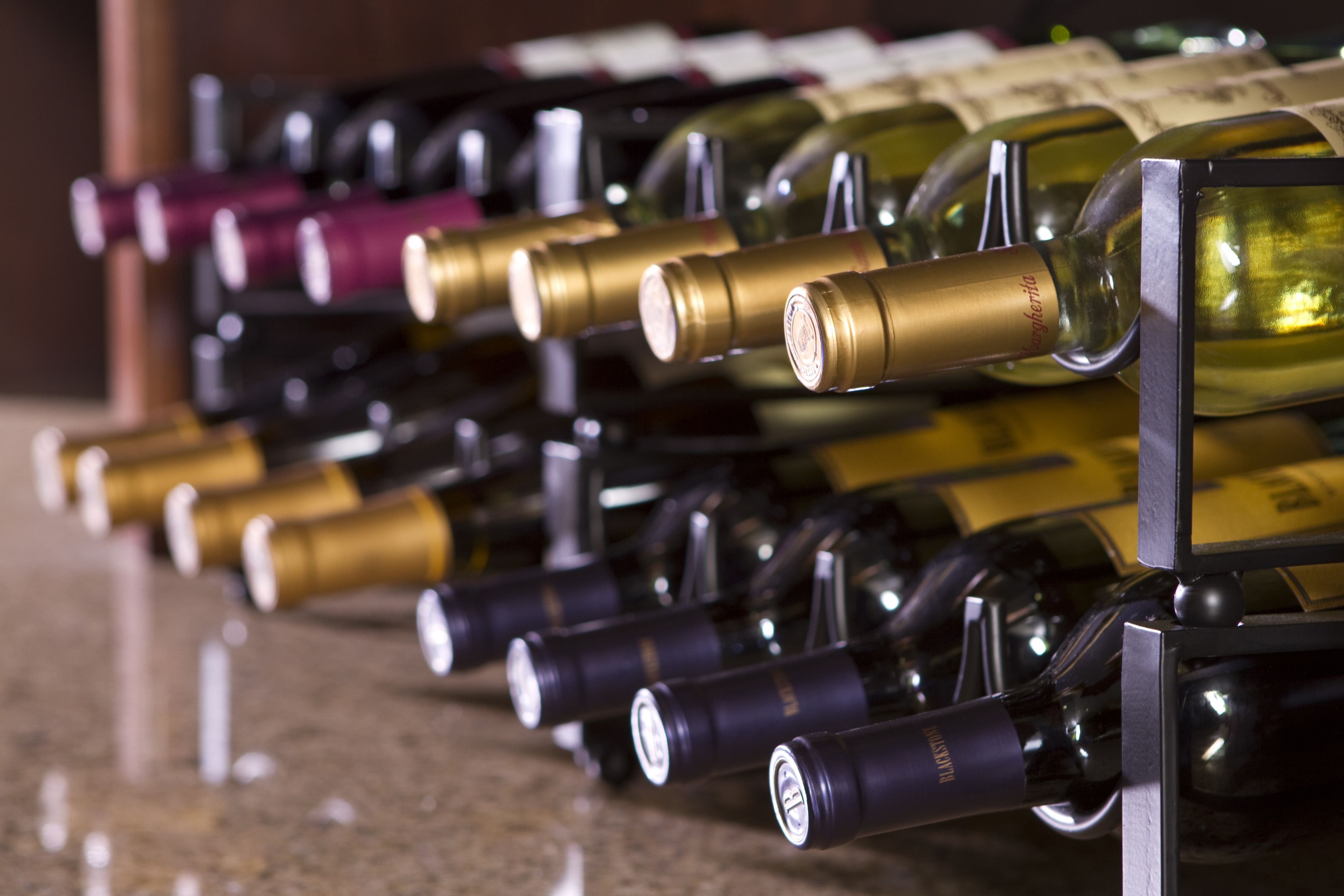A row of wine bottles on a rack.