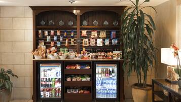 Un bar de aperitivos con estantes llenos de bocadillos y una vitrina refrigerada de bebidas.