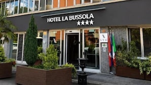 Un edificio de hotel de varios pisos con un cartel que dice 'HOTEL LA BUSSOLA' y una clasificación de tres estrellas.