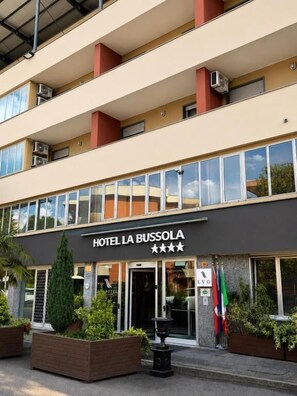 A multi-story hotel building with a sign reading 'HOTEL LA BUSSOLA' and a star rating of three stars. - LVG Hotel Collection - La Bussola (Novara)
