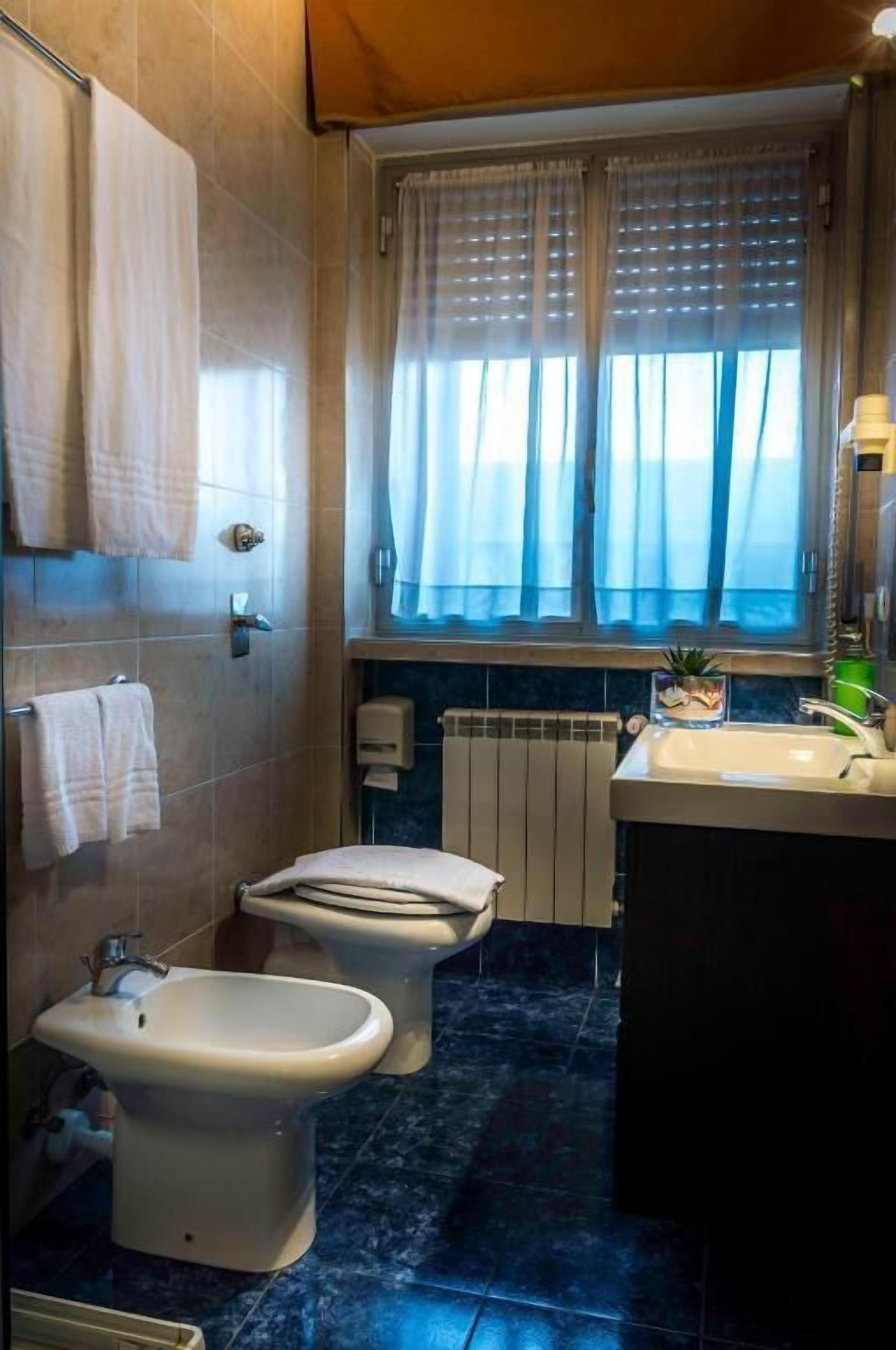 A bathroom with a toilet, bidet, and sink.