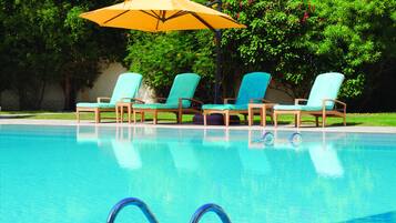 Een binnenzwembad, een buitenzwembad, parasols voor strand/zwembad